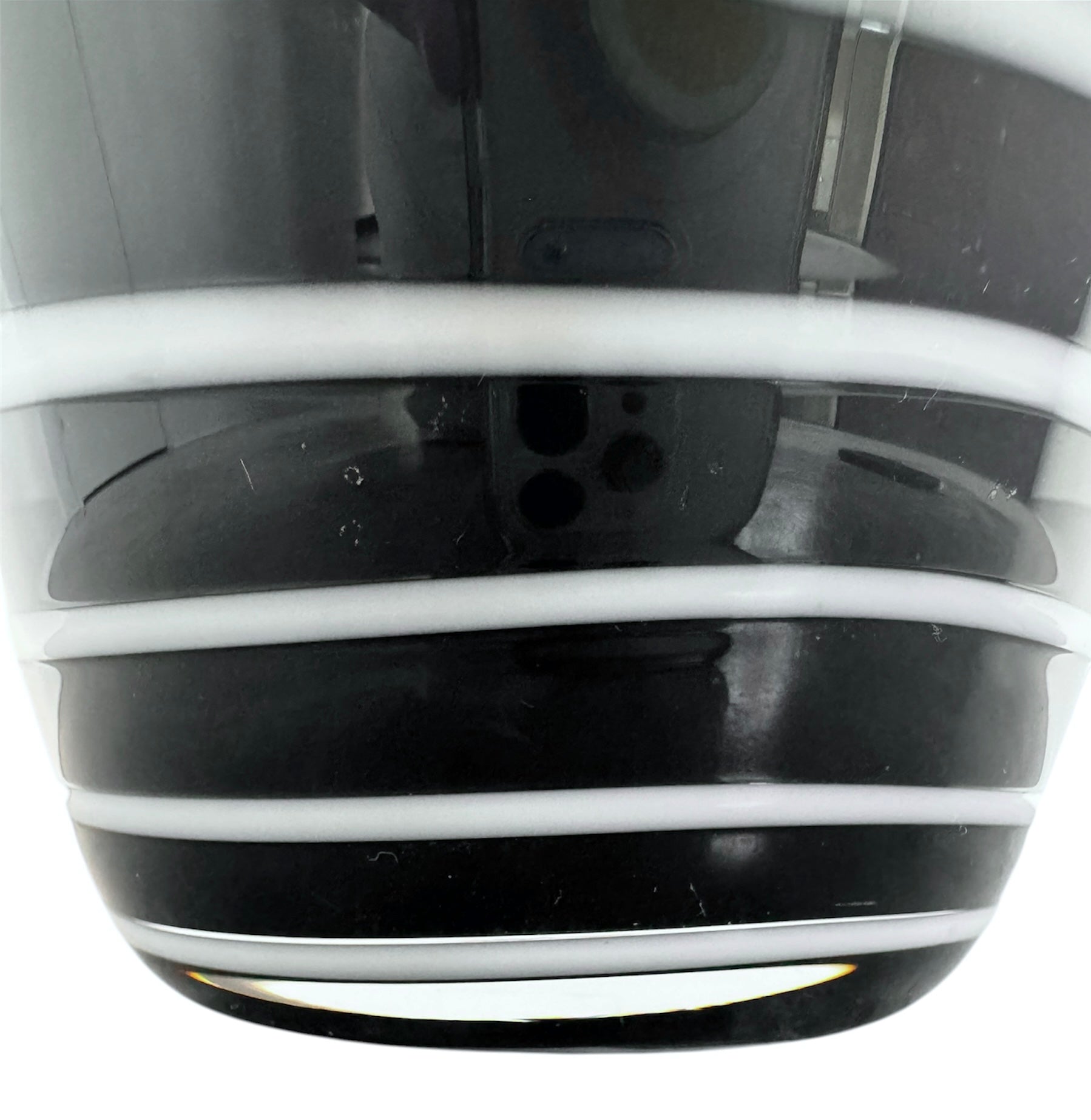 A sleek, hand-blown Polish art glass vase featuring a tall, slender neck that flares into a rounded, bulbous body. The vase is made of opaque black glass decorated with a continuous white spiral ribbon that winds around the entire piece from base to rim. The high-gloss, reflective surface creates sharp highlights, emphasizing its smooth, sculptural silhouette against a plain white background.
