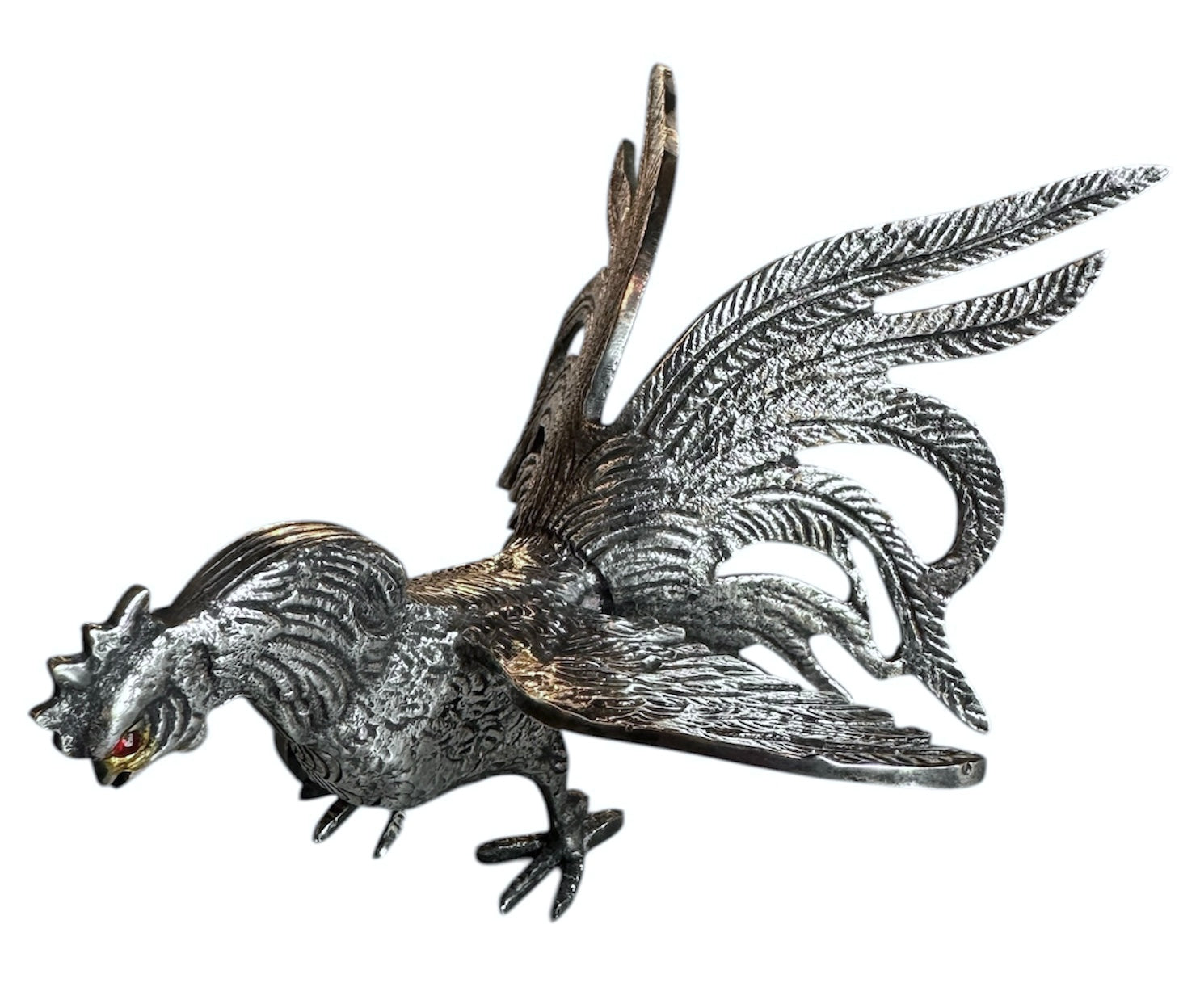 A pair of vintage, silver-plated brass fighting rooster figurines positioned in a confrontational stance against a white background. The rooster on the left is crouched low with its head down and tail feathers fanned high, while the rooster on the right stands more upright with its wings slightly flared. Both feature intricate feather detailing, a metallic patina showing hints of brass through the silver, and small, bright red glass eyes.