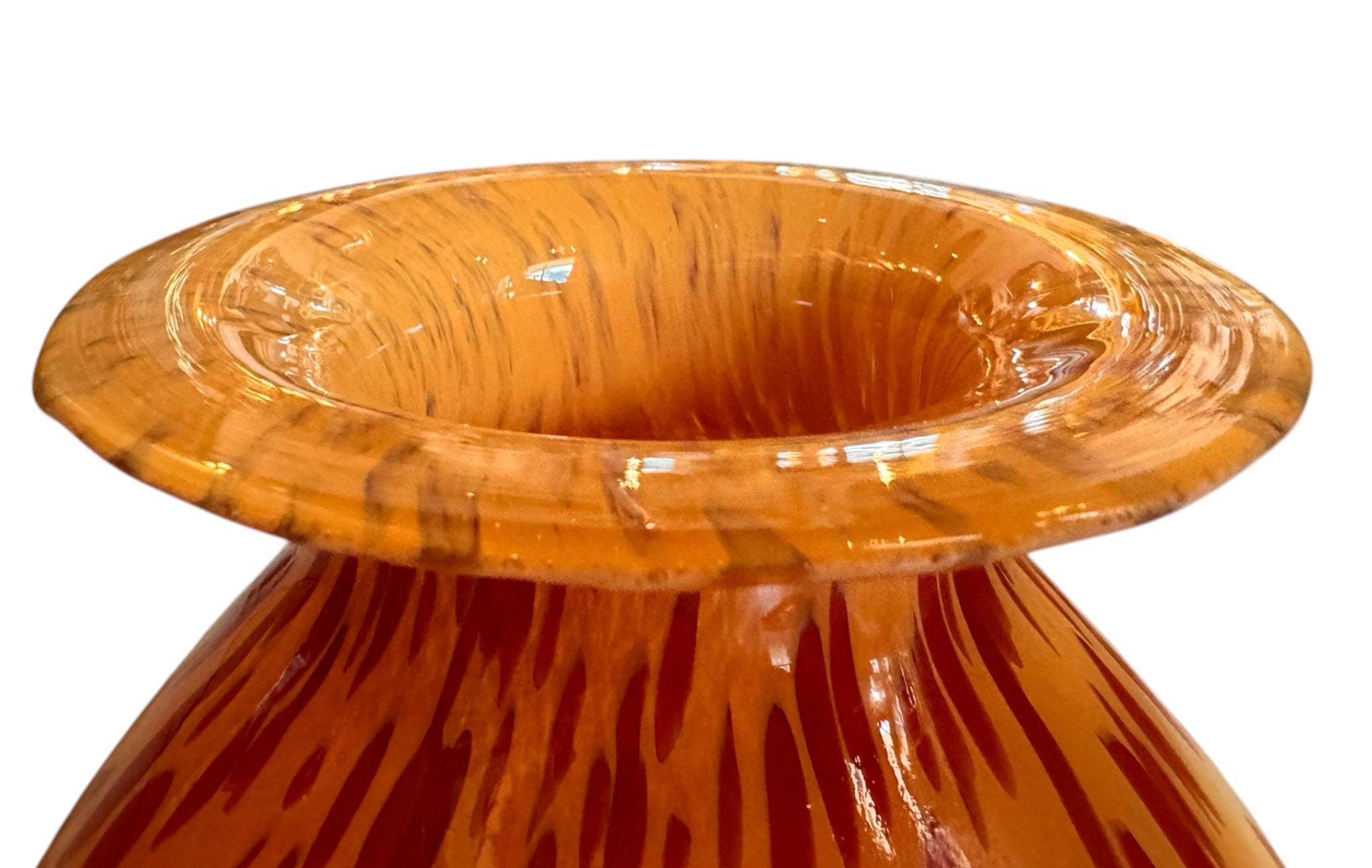 A hand-blown Italian Murano glass vase featuring a wide, bulbous body and a short, flared rim. The glass is a vibrant, translucent amber-orange base decorated with an organic "macchia" or spotted pattern of deep ruby red blotches. The red spots are elongated and vertical near the neck, becoming larger and more rounded toward the base. The surface has a high-gloss, reflective finish, showcasing mid-century modern craftsmanship.
