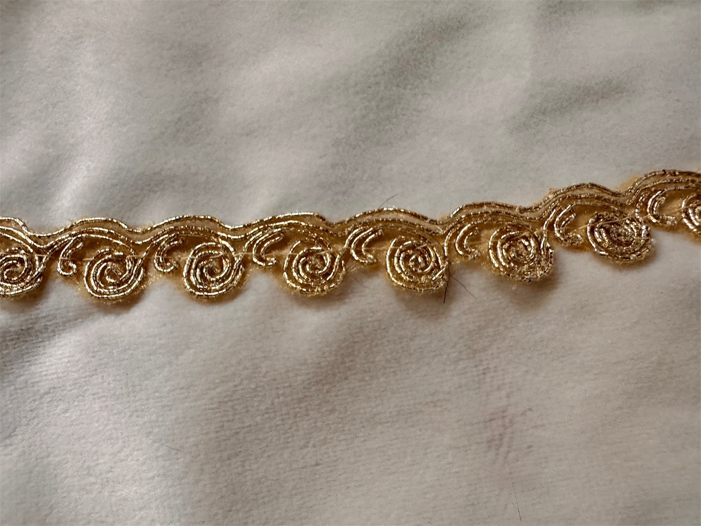 A round, cream-colored tablecloth featuring a dramatic, scalloped border shaped like six large flower petals. The border is intricately embroidered with a coastal motif including pink starfish, seashells, and teal-blue swirling waves. Gold beaded accents line the inner circular seam and the outer edges.
A long, narrow cream runner with matching scalloped, wavy edges. It is adorned with the same nautical embroidery of pink starfish and seashells scattered across the center and concentrated along the edge.