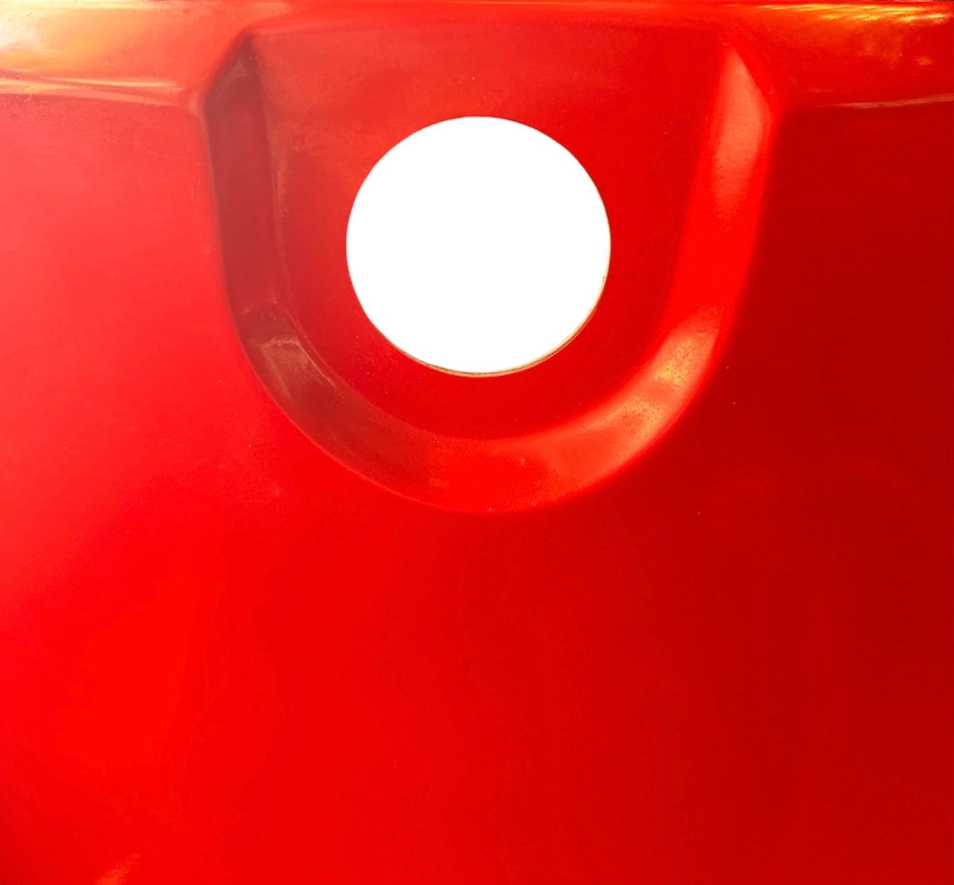 A top-down, straight-on view of a vintage, high-gloss cherry red bathtub. The tub basin is molded into a distinct double-tiered heart shape, with a shallower outer heart cascading into a deeper, smaller inner heart basin centered within a wide rectangular red deck.