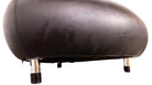 A Leolux Pallone armchair with a large, black, spherical leather seat and a smaller, red, curved leather backrest, supported by short metal legs.