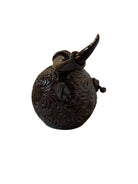 Glossy dark brown ceramic bull sculpture with intricate, hand-incised swirling patterns and a nose ring.