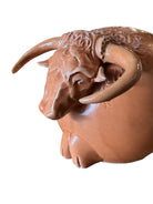 Terracotta colored ceramic Highland cow sculpture with a shaggy coat and curved horns