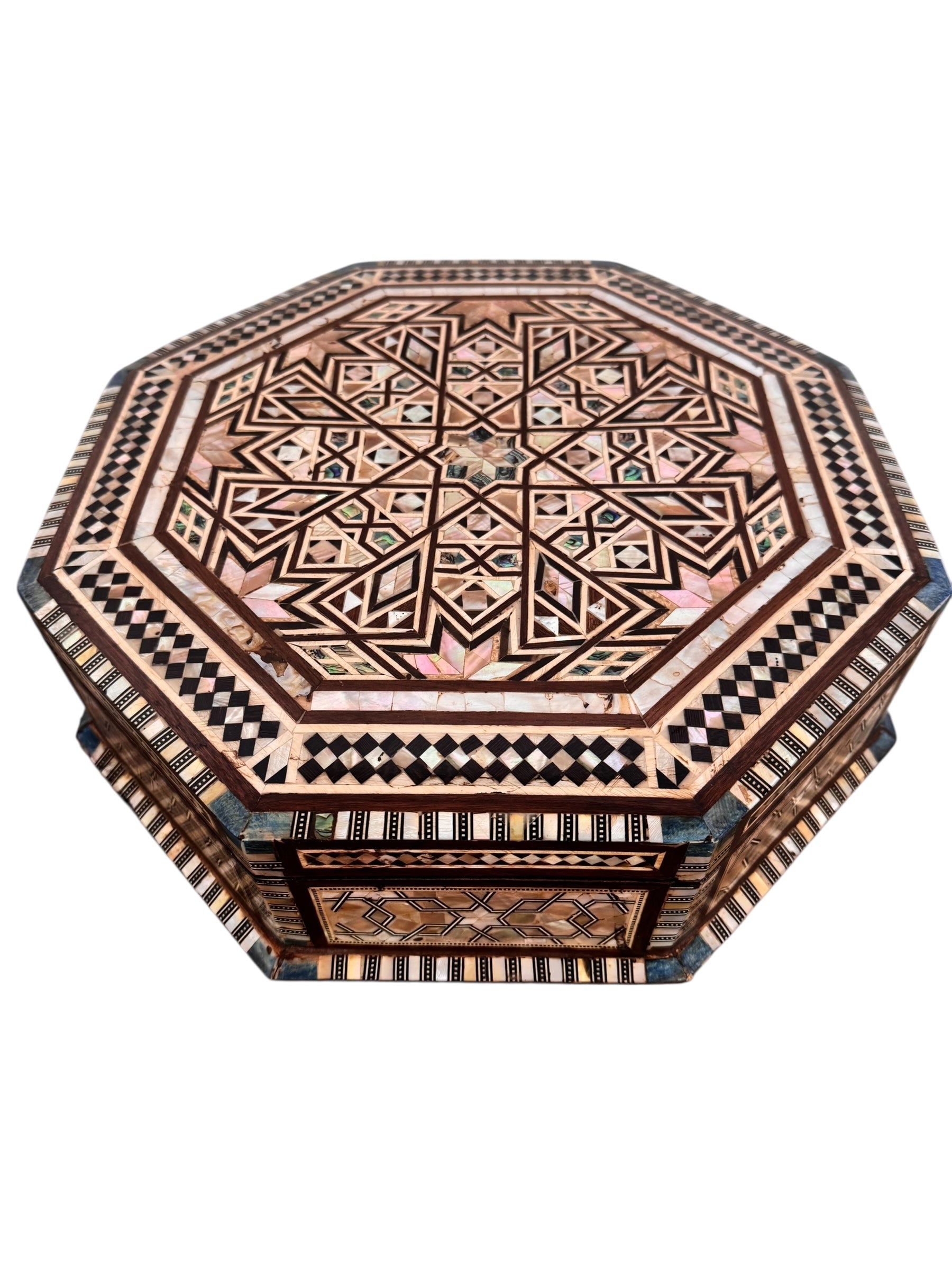 An ornate octagonal Syrian inlaid box, intricately decorated with geometric patterns made from dark wood, iridescent mother-of-pearl, vibrant abalone shell, and pale bone
