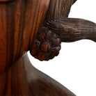 An elegant hand-carved bust of a woman made from rich, polished dark ebony wood with striking reddish-brown grain patterns running vertically through her face and chest. The sculpture features a serene expression with closed eyes, a slender nose, and relaxed lips. Her voluminous, textured hair rises upward in a Fan-like shape, intricately carved with fine lines and adorned with small, delicate flower details. The bust includes her bare shoulders and upper chest, resting on a flat base.