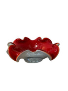 A Murano art glass bowl featuring a vibrant red interior encased in white glass, with a decorative ruffled edge. The piece is handblown, showcasing the Incamiciato technique.
