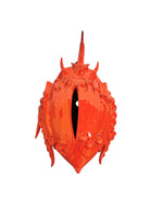 A glossy, vibrant orange ceramic sculpture of a rhinoceros beetle by Enza Fasano. The piece features a highly polished, reflective glaze and stylized, fluid anatomical details. Its prominent dual horns curve forward, and the body is textured with layered, wing-like plates, set against a plain white background.