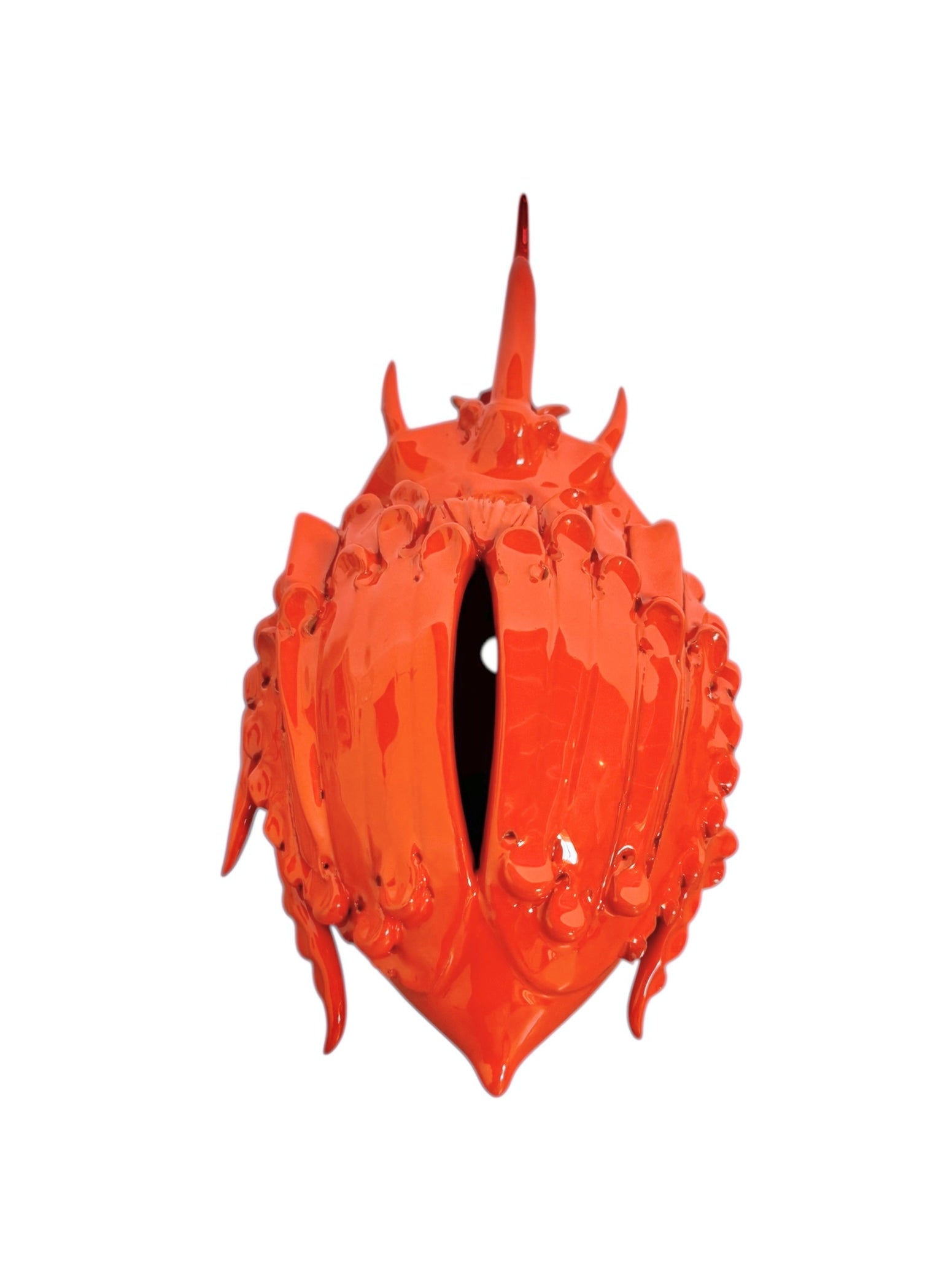 A glossy, vibrant orange ceramic sculpture of a rhinoceros beetle by Enza Fasano. The piece features a highly polished, reflective glaze and stylized, fluid anatomical details. Its prominent dual horns curve forward, and the body is textured with layered, wing-like plates, set against a plain white background.