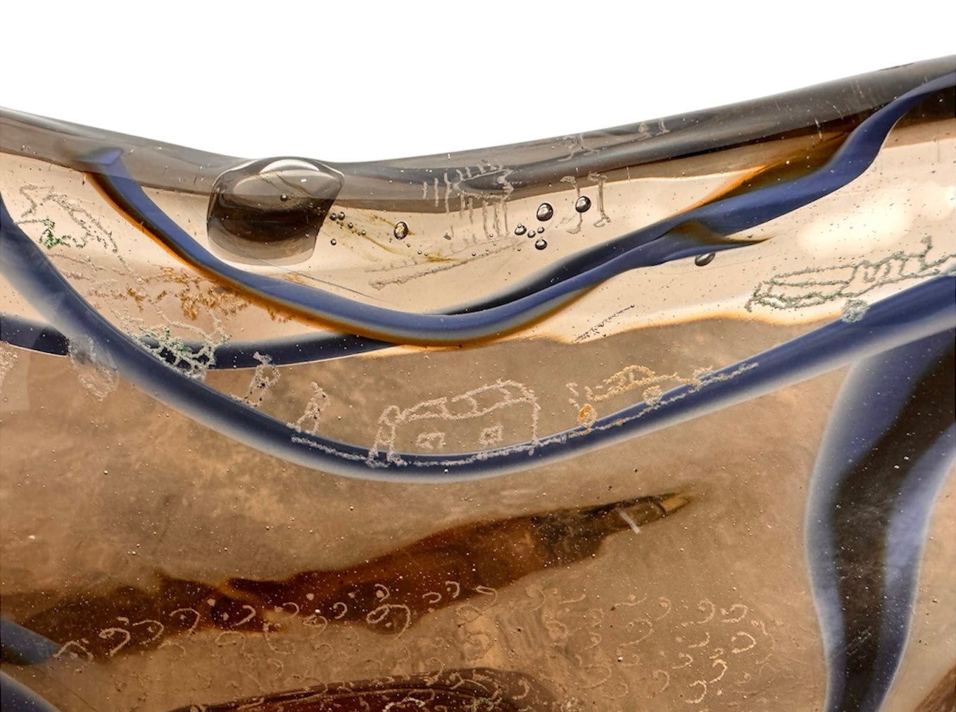 An asymmetrical Murano art glass sculpture with a heavy, biomorphic form. The piece is composed of thick, translucent smoky-amber glass with abstract, fluid bands of deep blue and dark brown swirling throughout the upper rim and sides. A dense pattern of tiny, controlled air bubbles is suspended inside the glass, concentrating heavily near the thick, solid amber base.