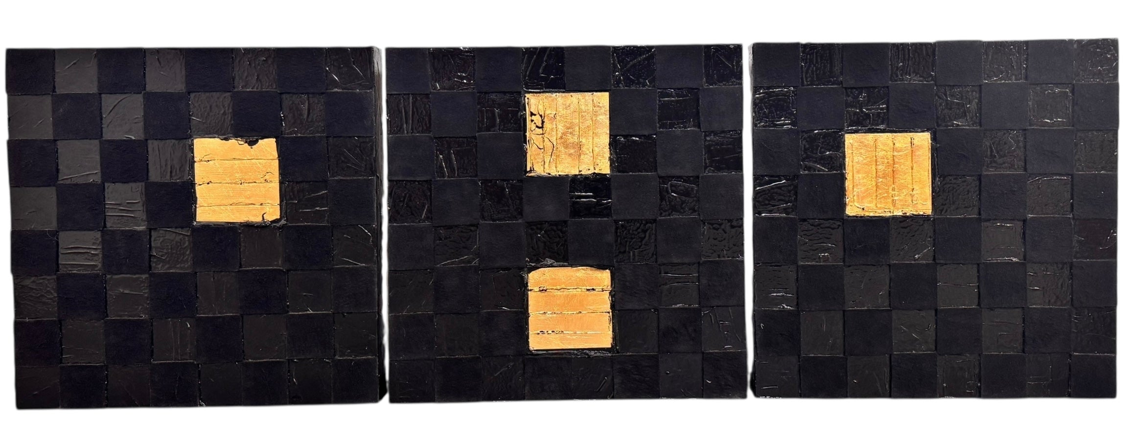 A triptych of abstract paintings featuring a grid pattern of textured black squares by Sabine Stromeyer called “Square One”. The left and right panels each have a single vertical gold rectangle in the center, while the middle panel has two stacked gold rectangles in the center.