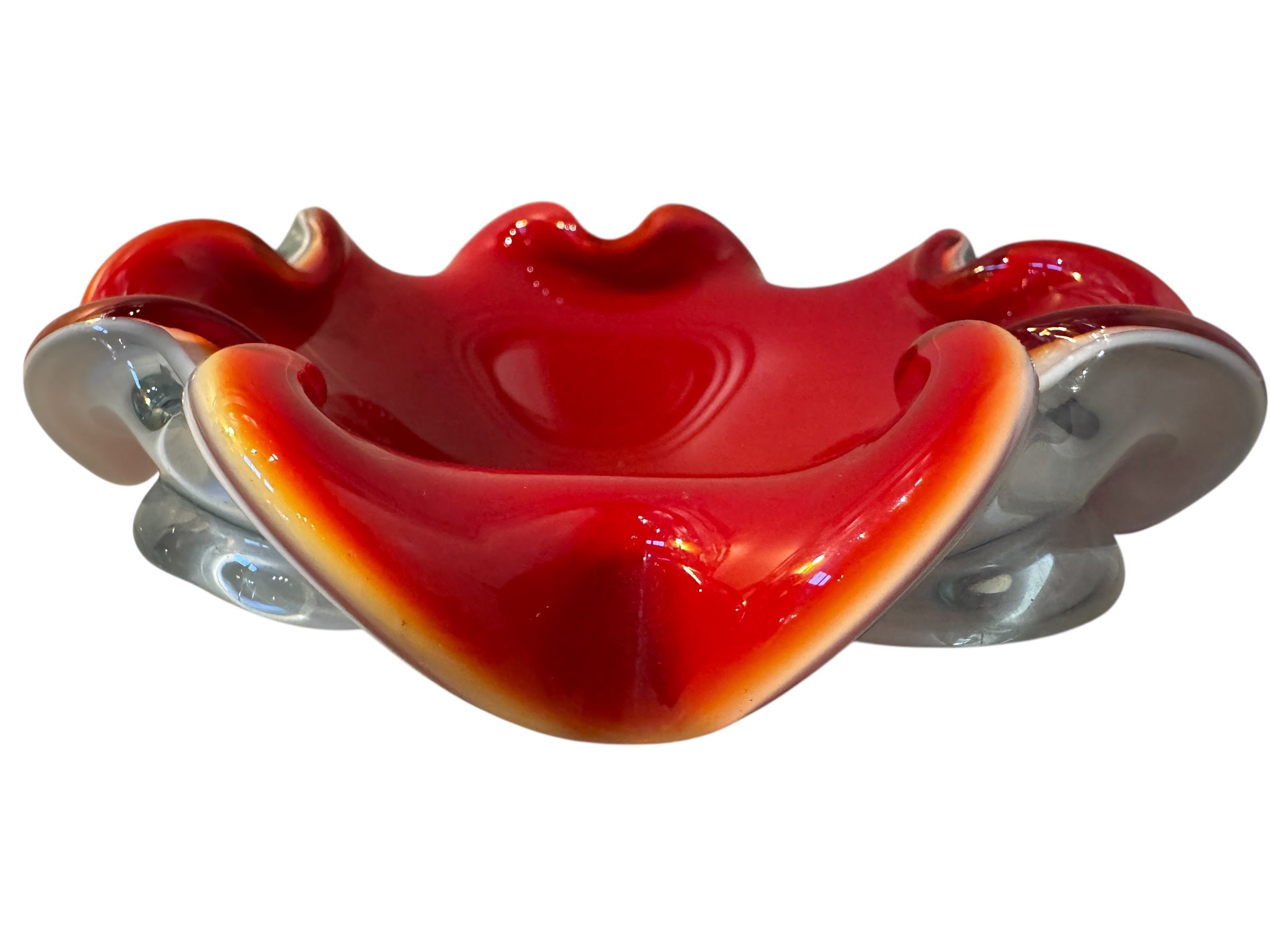 A Murano art glass bowl featuring a vibrant red interior encased in white glass, with a decorative ruffled edge. The piece is handblown, showcasing the Incamiciato technique.