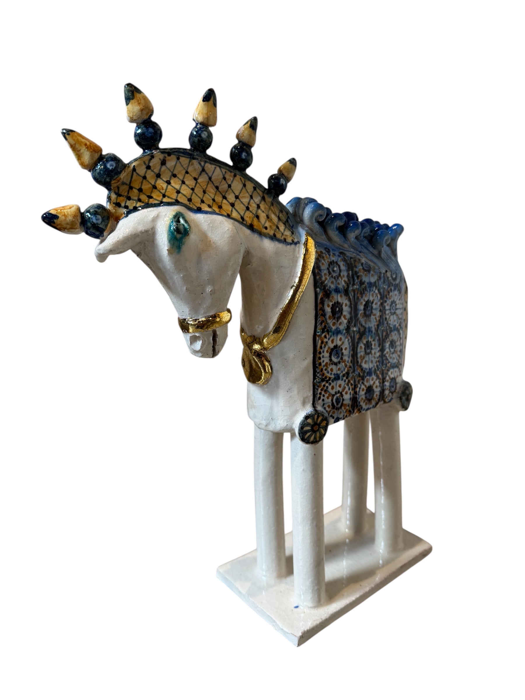 Ceramic horse by Domenico Pinto, featuring a white glazed body, geometric quilting on the saddle, a decorative crown with black and gold accents, and 24Kt gold detailing. The horse stands on four legs and is placed on a white base.