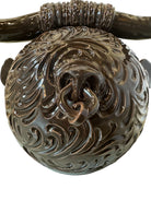 Glossy dark brown ceramic bull sculpture with intricate, hand-incised swirling patterns and a nose ring.