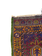 Anatolian Yastik rug with red, gold, green and gray geometric patterns and fringe.
