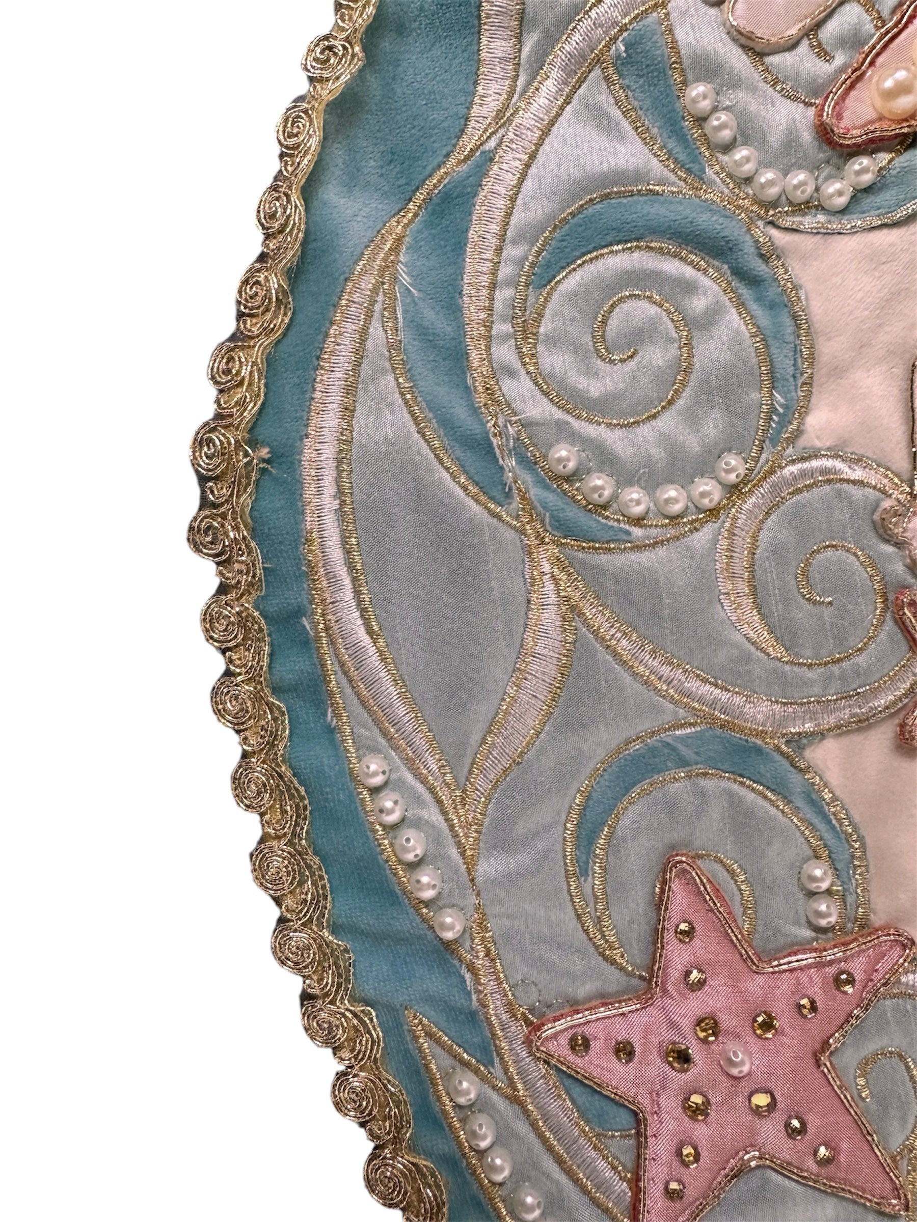 A round, cream-colored tablecloth featuring a dramatic, scalloped border shaped like six large flower petals. The border is intricately embroidered with a coastal motif including pink starfish, seashells, and teal-blue swirling waves. Gold beaded accents line the inner circular seam and the outer edges.
A long, narrow cream runner with matching scalloped, wavy edges. It is adorned with the same nautical embroidery of pink starfish and seashells scattered across the center and concentrated along the edge.