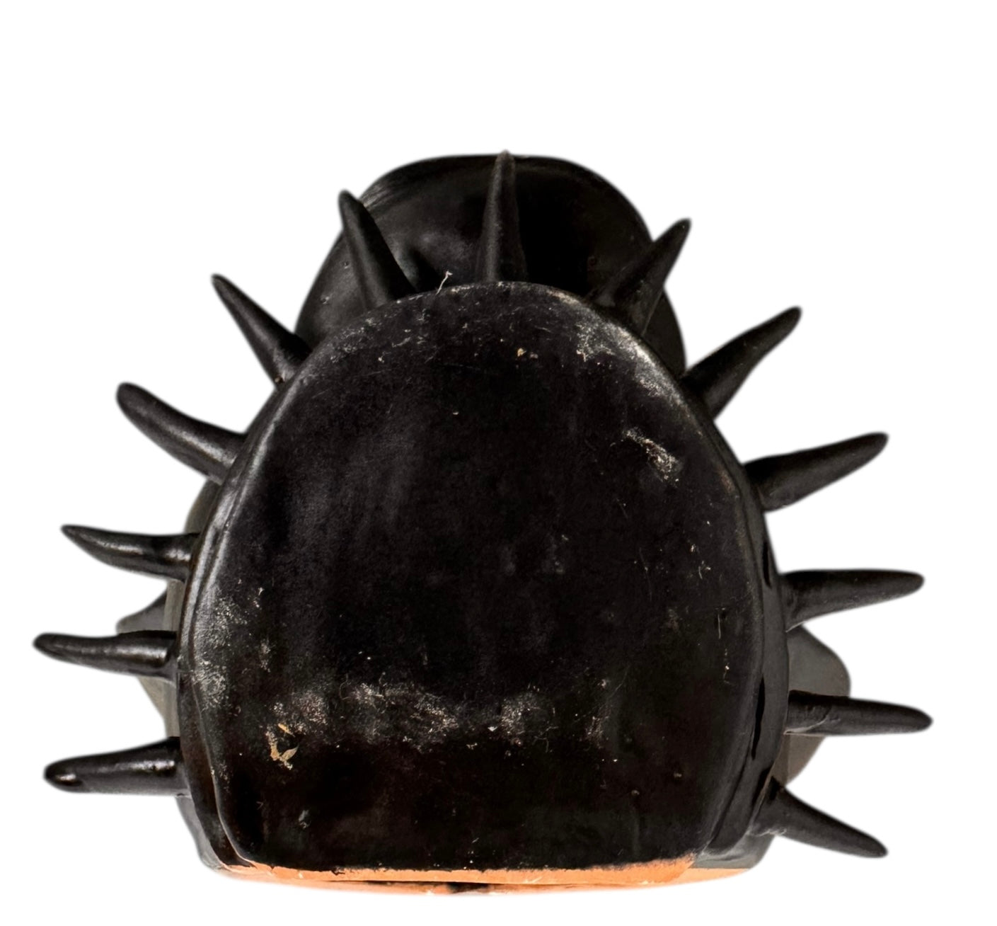 A smooth, dark black-colored ceramic sculpture of a Miniature Pinscher's head. The stylized dog features large, upright pointed ears and a prominent spiked collar around its neck. The surface has a soft sheen, with minimalist indentations for eyes and a rounded snout, creating a sleek and modern aesthetic.