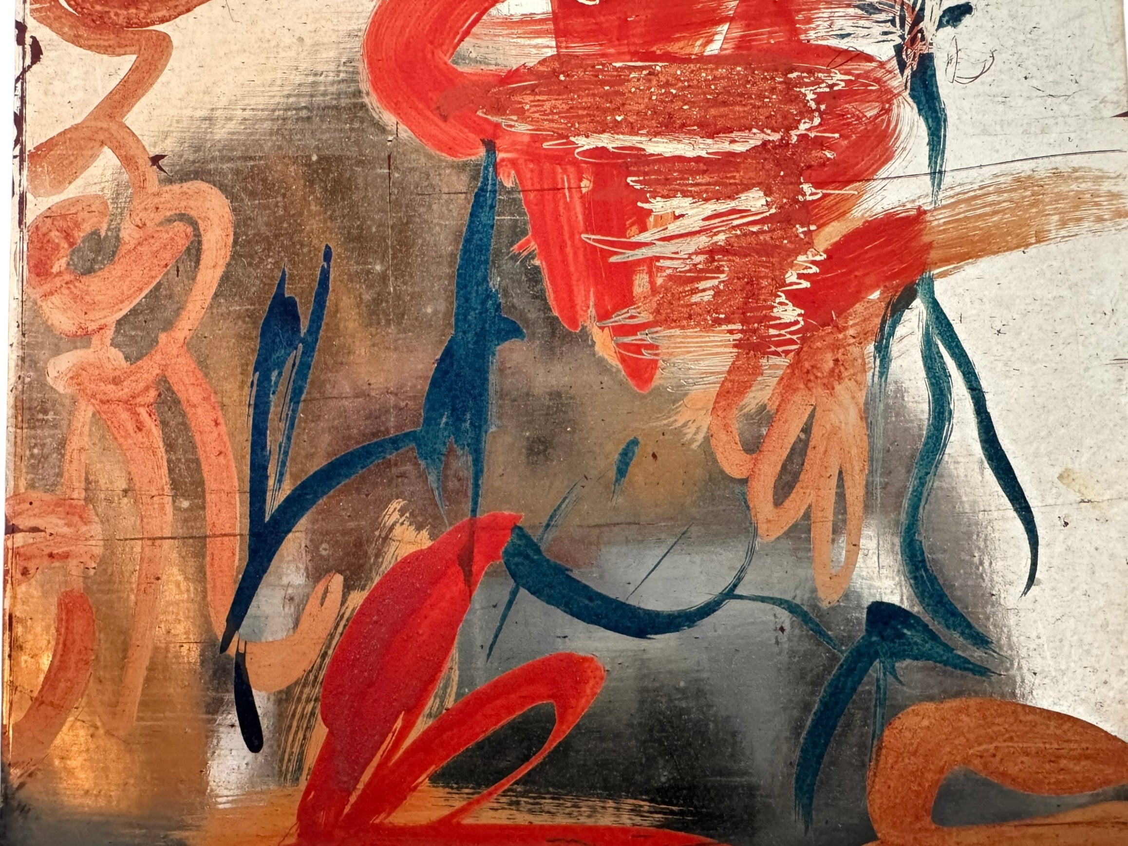A vertical composition on a bright, reflective metallic background (likely silver or light gold leaf). The piece is defined by sparse, high-energy gestures: a sweeping arc of orange and red at the top, a central cluster of textured red paint, and a scattering of teal-blue "C" shapes and hooks. The metallic surface is highly visible, giving the piece a luminous, modern feel.