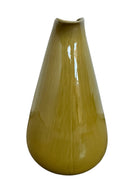 A chartreuse (yellow-green) ceramic pitcher designed by Russel Wright, featuring a teardrop shape, an elongated spout, and a curved handle