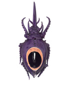 A glossy, deep purple ceramic sculpture of a beetle by Enza Fasano. The piece features a highly stylized and ornate design, blending insect-like anatomy with fantastical elements. It has a smooth, rounded shell and elongated, curved mandibles and appendages lined with sharp, thorn-like protrusions. The monochromatic glaze is reflective, highlighting the intricate sculptural details and textures of the avant-garde artwork.