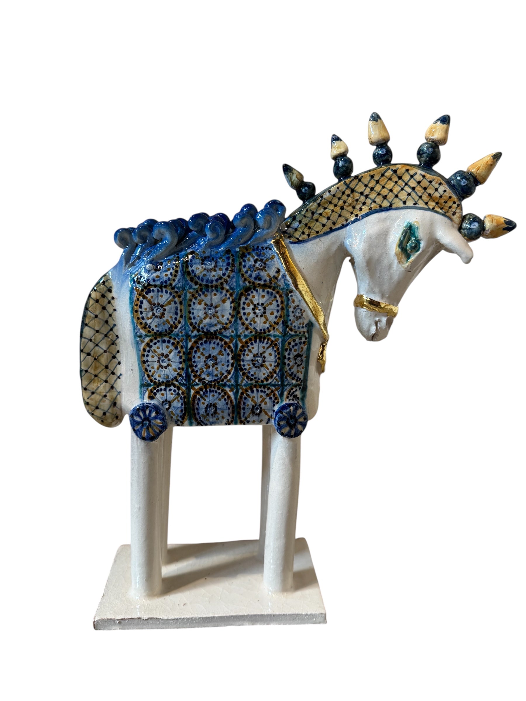 Ceramic horse by Domenico Pinto, featuring a white glazed body, geometric quilting on the saddle, a decorative crown with black and gold accents, and 24Kt gold detailing. The horse stands on four legs and is placed on a white base.