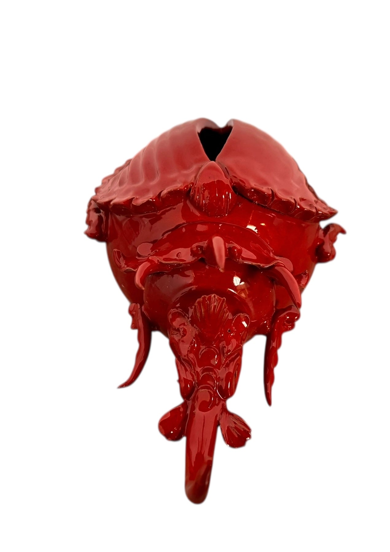 A vibrant, glossy red ceramic sculpture of a rhinoceros beetle by Enza Fasano. The piece features a highly reflective, deep crimson glaze that accentuates its smooth, rounded abdomen and the intricate, jagged textures of its head and horns.