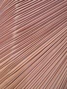 A table lamp featuring a teardrop-shaped, reddish-purple glass base and a conical, pleated, light-pink fabric shade.