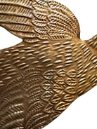 mage of a vintage-style, gilded tin bird with embossed feather detailing. A green velvet ribbon is attached. Front and back views shown.