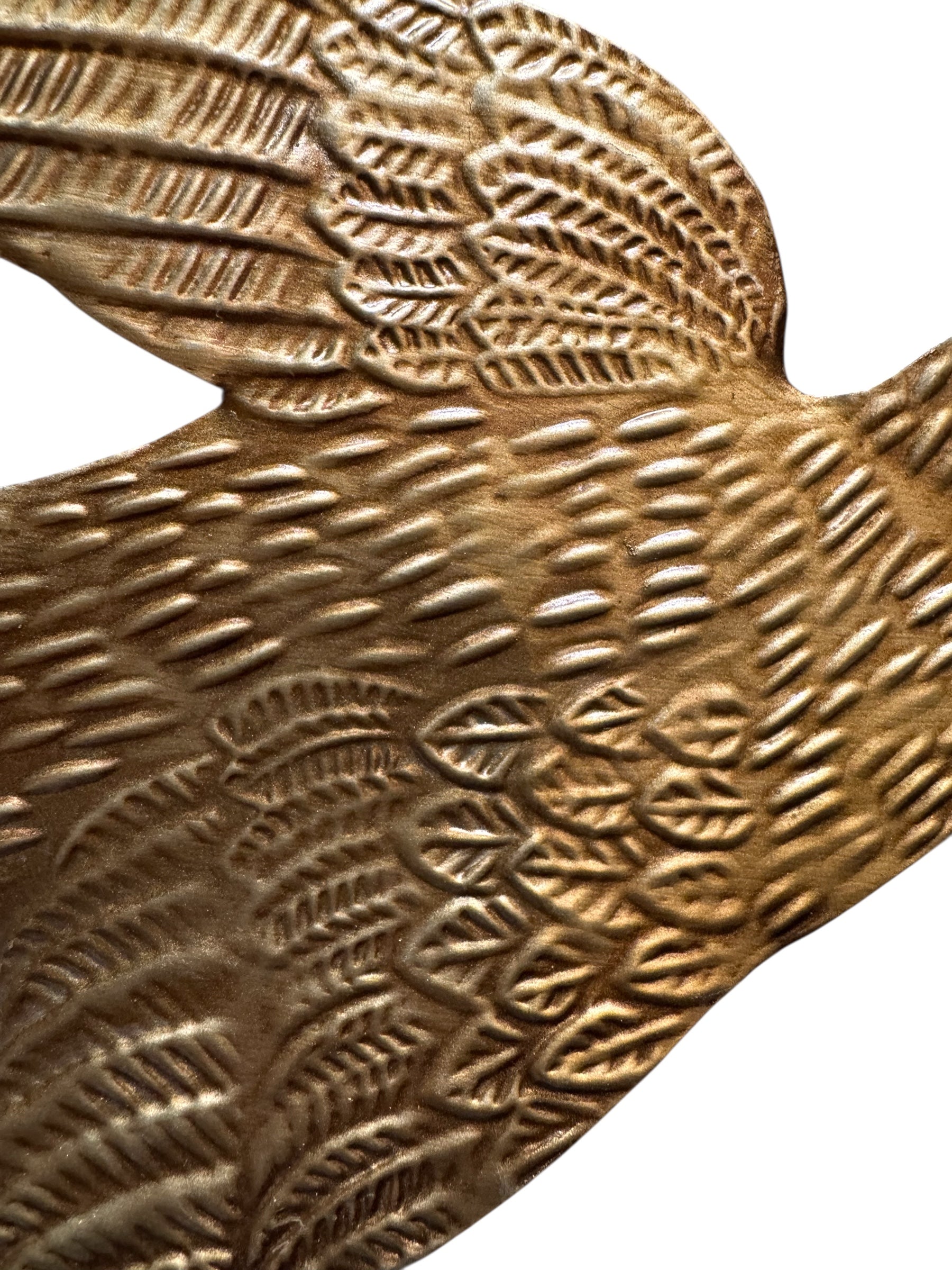 mage of a vintage-style, gilded tin bird with embossed feather detailing. A green velvet ribbon is attached. Front and back views shown.