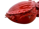 A vibrant, glossy red ceramic sculpture of a rhinoceros beetle by Enza Fasano. The piece features a highly reflective, deep crimson glaze that accentuates its smooth, rounded abdomen and the intricate, jagged textures of its head and horns.
