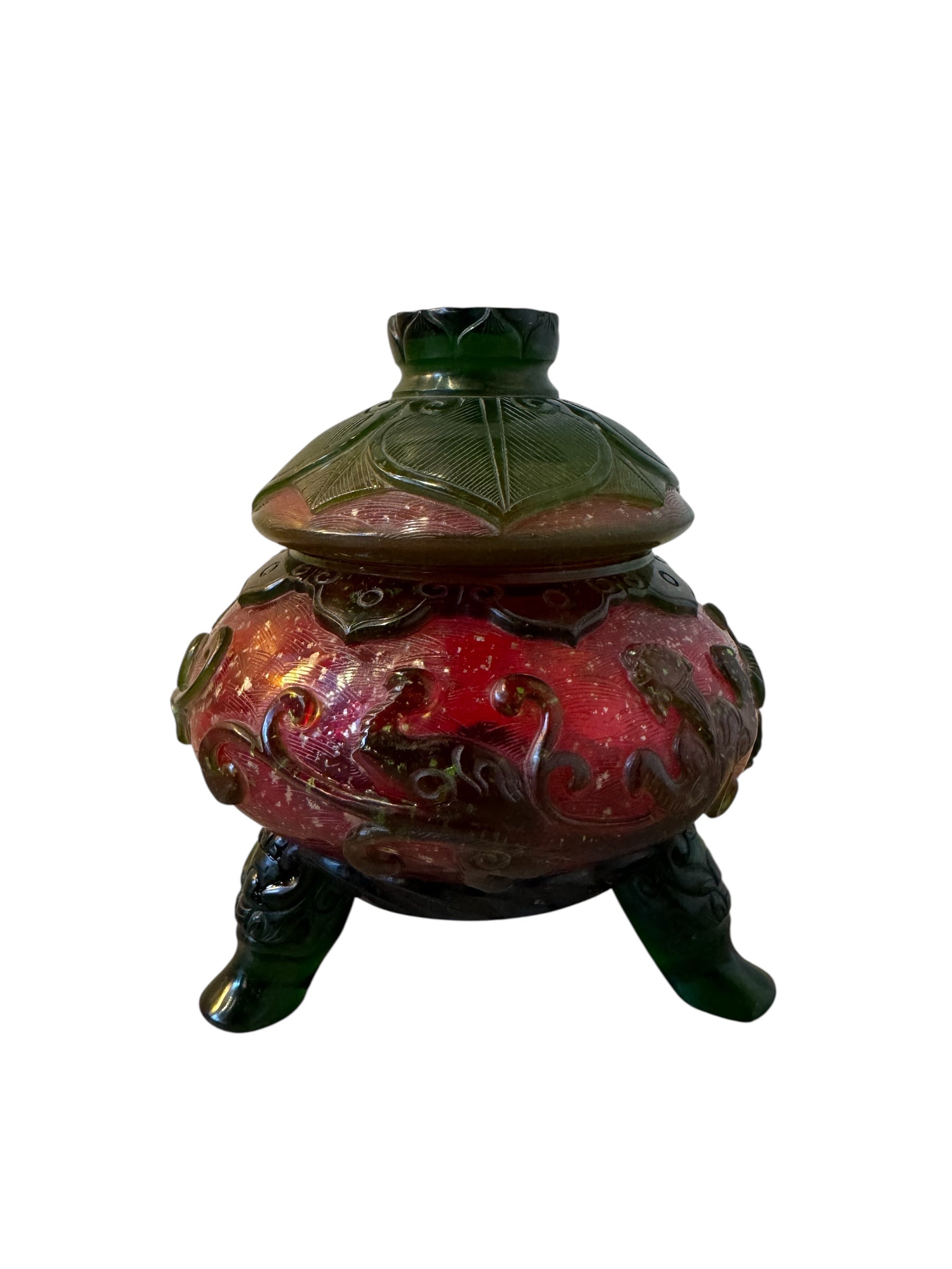Close-up of a Qianlong-style Peking overlay glass censer. The red glass body is decorated with a carved green overlay design. The censer has a green lotus-carved lid and sits on three feet. A seal mark is visible on the base
Century_Qianlong-Style_Peking_Glass_Censer