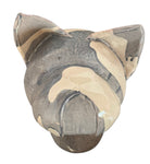A ceramic sculpture of a bulldog's head by Enza Fasano. The piece features a glossy, glazed finish with a sophisticated color palette of muted greys, creams, and earthy brown tones arranged in bold, abstract striped patterns across the face and ears. The bulldog has characteristic folded ears, a prominent snout, and a soulful, slightly downturned expression. The sculpture is set against a clean, white background, highlighting its smooth texture and reflective surface.