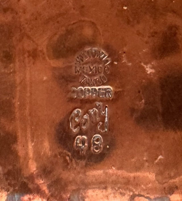 The set includes a large, rectangular, hammered copper tray with geometric openwork handles. Resting on the tray is a tall, slightly tapered copper coffee pot with a wooden handle, a matching smaller creamer pitcher with a similar wooden handle, a lidded sugar bowl, and a tiny matching metal cup or jigger. To the right off the tray sits a large, spherical copper water pitcher or jug with a wide mouth and ice lip.