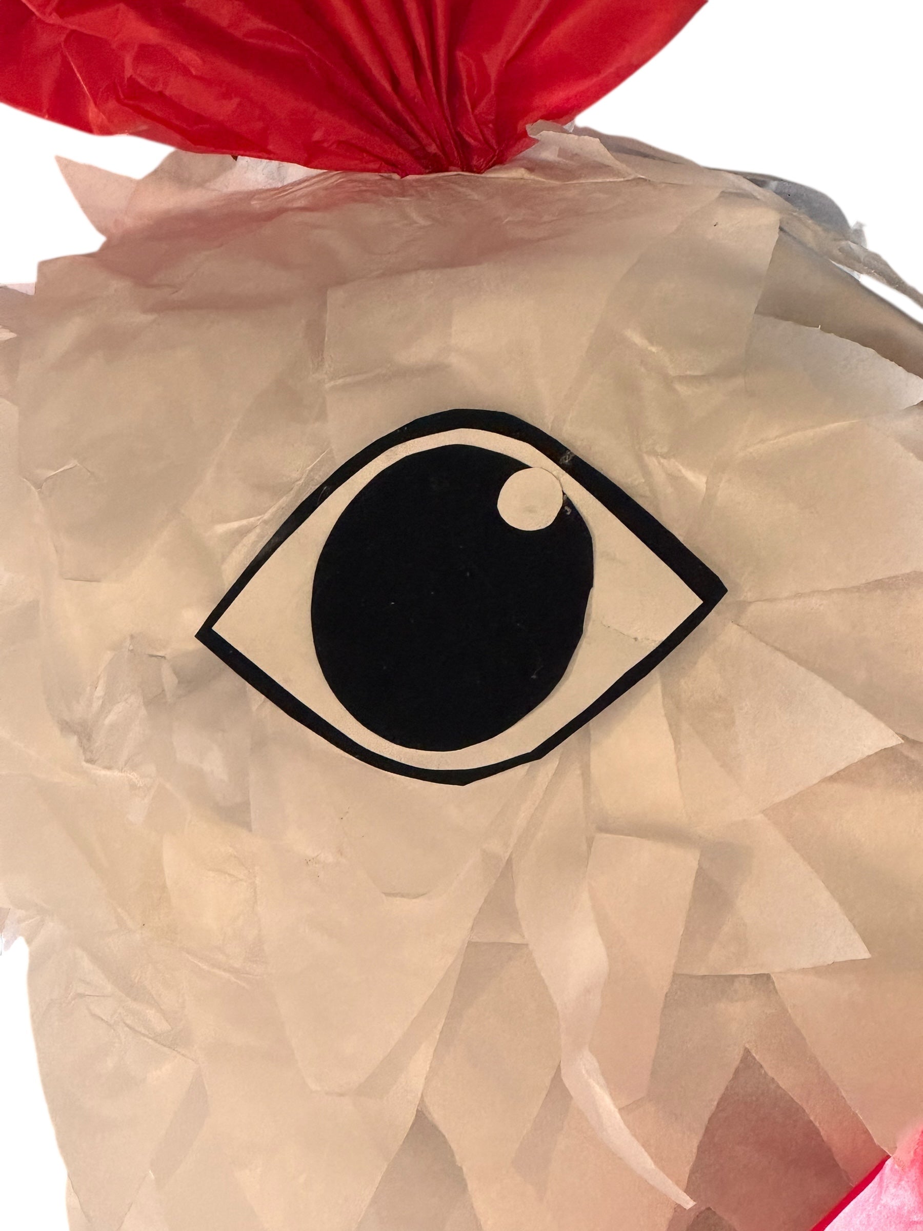 A white chicken pinata with red comb and wattles, and orange beak and legs, standing upright.