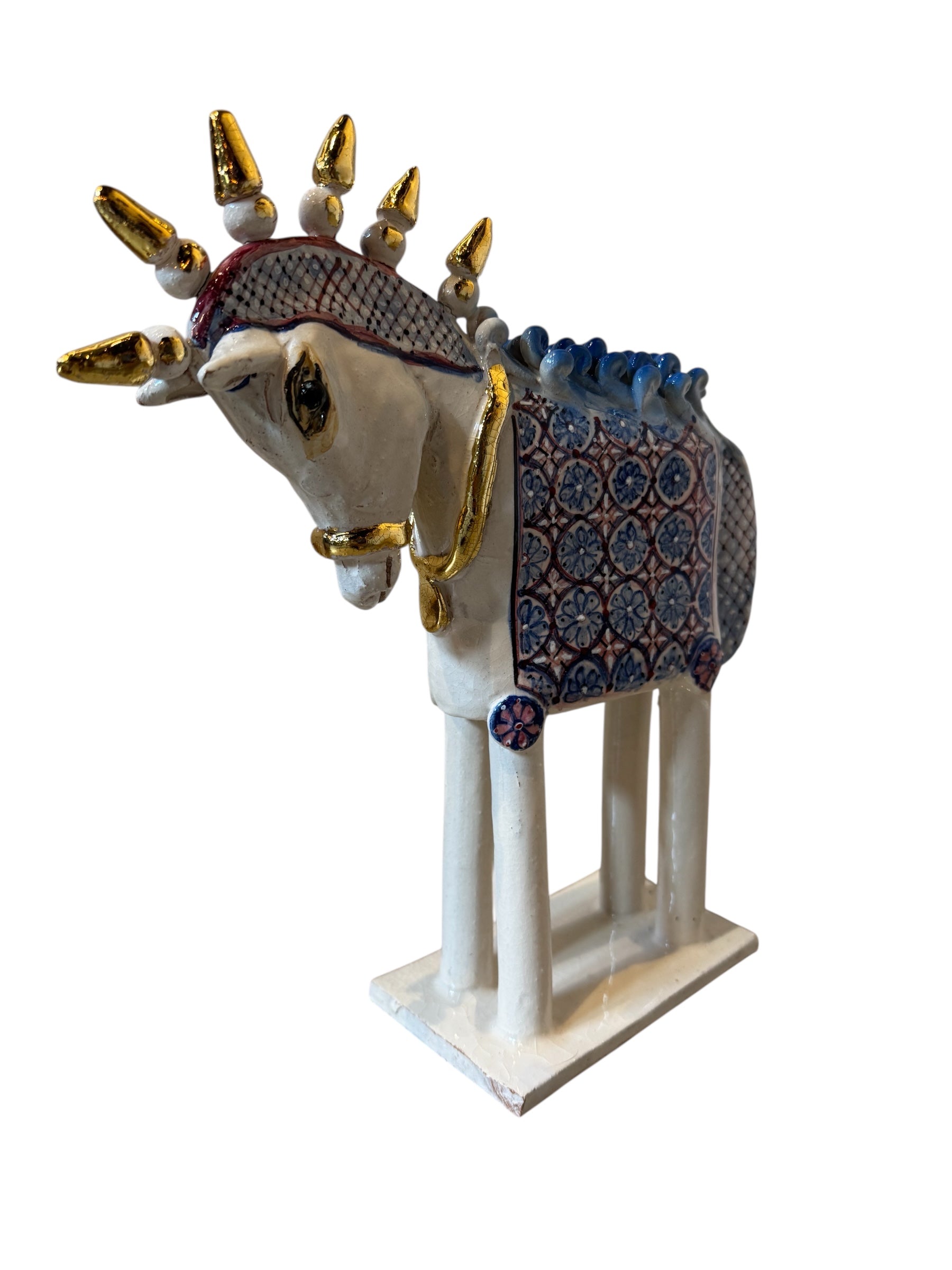 Ceramic horse by Domenico Pinto, featuring a white glazed body, geometric quilting on the saddle, a decorative crown with white and gold accents, and 24Kt gold detailing. The horse stands on four legs and is placed on a white base.
