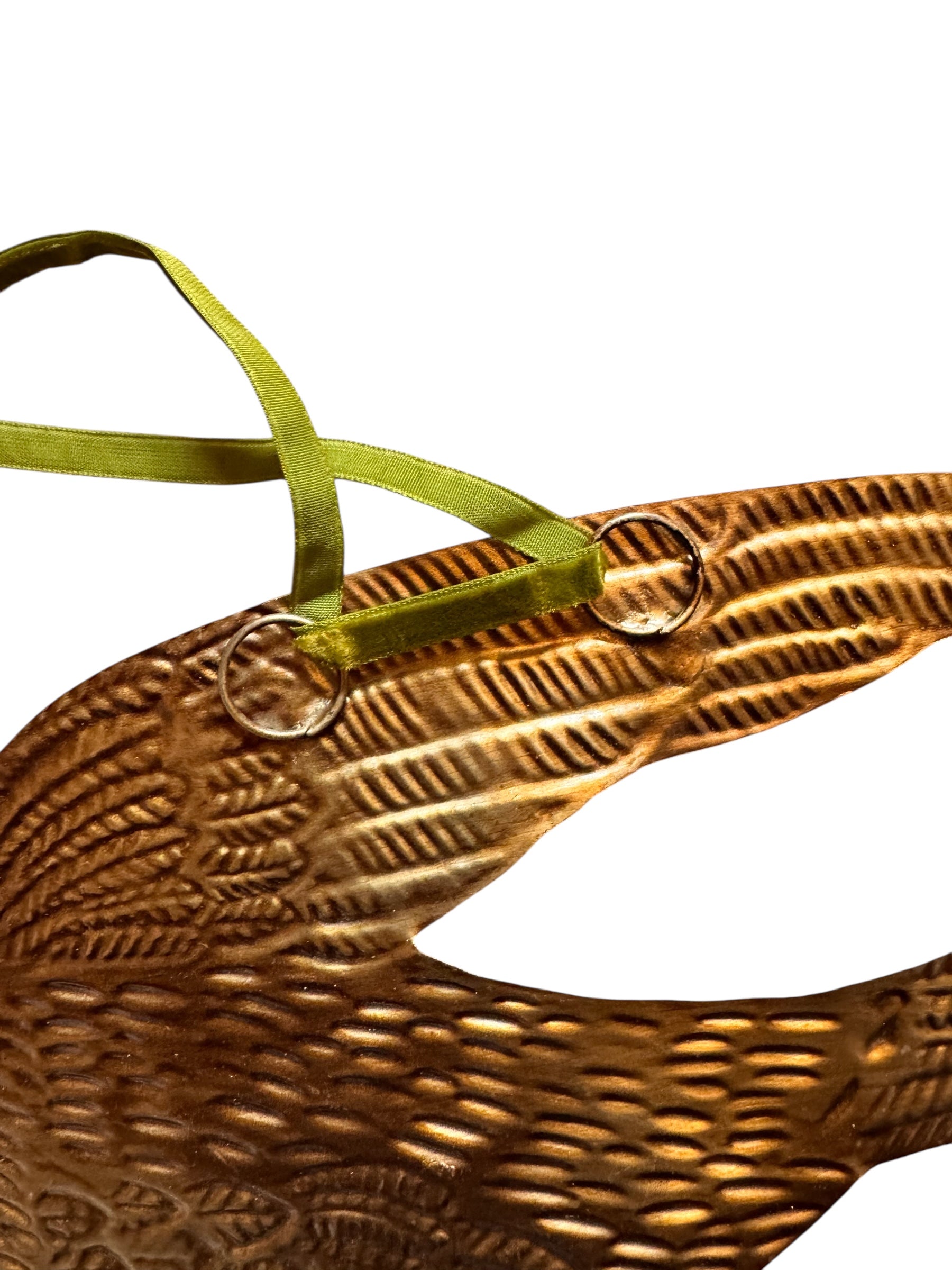 mage of a vintage-style, gilded tin bird with embossed feather detailing. A green velvet ribbon is attached. Front and back views shown.
