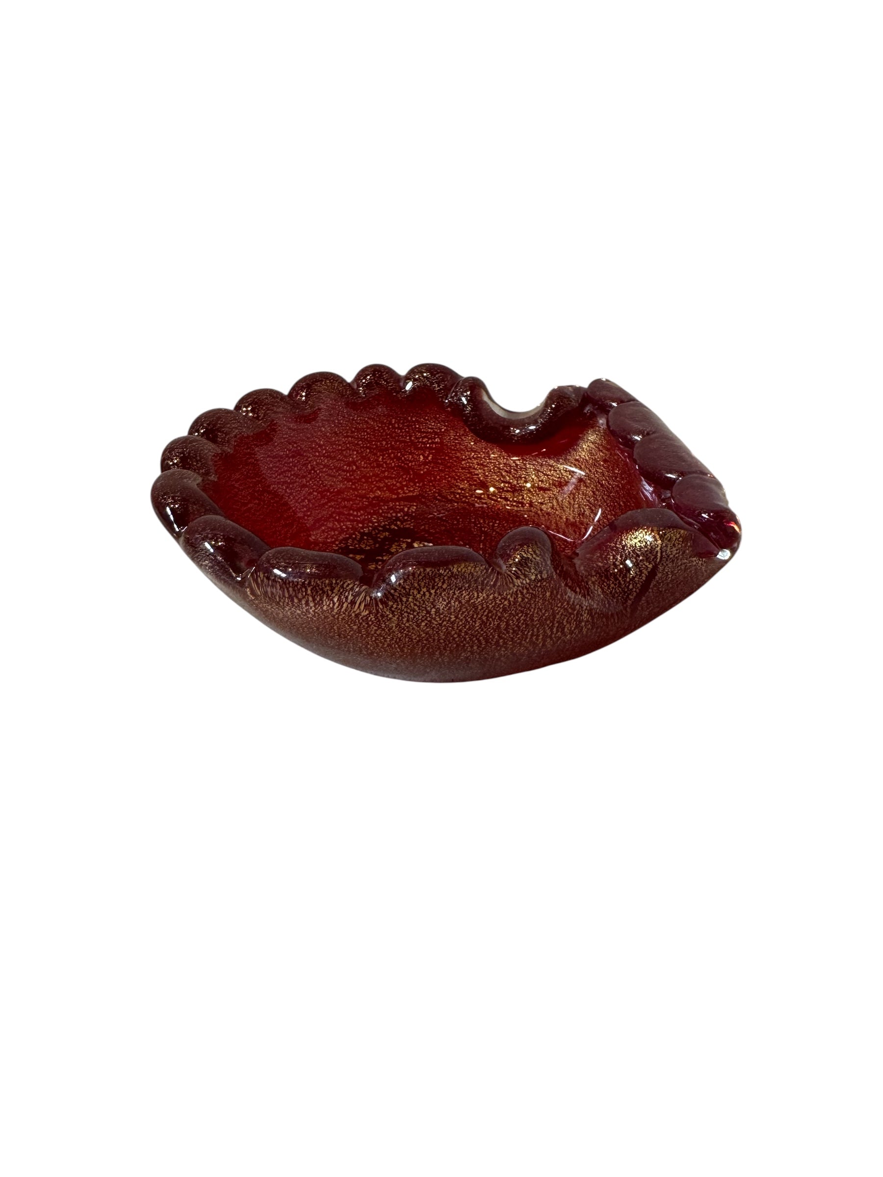 A handcrafted Murano glass bowl with a ruffled edge, deep red color, and gold specks created using the "oro zecchino" technique. The surface has a crackled gold pattern that reflects light, making it a striking decorative piece.
