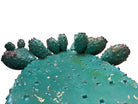 A green and red, glazed ceramic platter in the shape of a prickly pear cactus pad with attached prickly pear fruit. The surface has raised dots representing spines. 