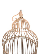 A single, white or cream-colored, decorative wrought iron bird cage with a hinged door and a hanging loop at the top. The cage has a vintage or antique style 