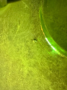 A vintage, Mid-Century Modern, peridot green art glass ashtray or catchall bowl with a curved, free-form design.