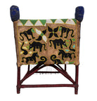 Close-up of a Yoruba beaded armchair, featuring vibrant red, blue, and green beads in a pattern of stylized masks and animals such as lions and zebras