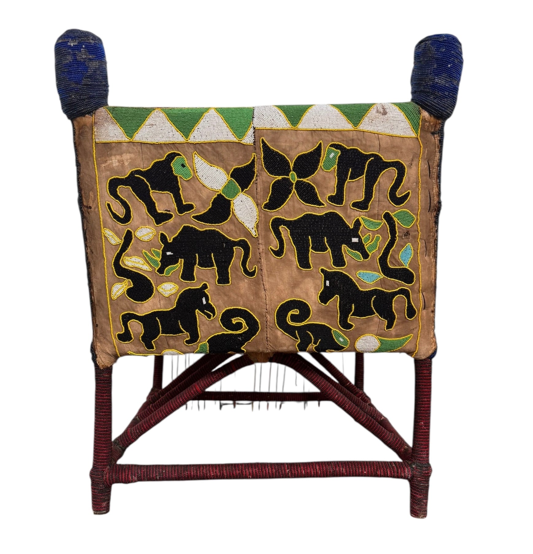 Close-up of a Yoruba beaded armchair, featuring vibrant red, blue, and green beads in a pattern of stylized masks and animals such as lions and zebras