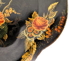 A vintage rectangular toleware serving tray with a scalloped, wavy edge and a black lacquered finish. The tray features hand-painted floral motifs in a traditional folk-art style. At the bottom center is a large, vibrant cluster of yellow and orange roses and daisies with green leaves. Smaller floral sprays and delicate gold filigree scrollwork decorate the corners and the upper rim. The center of the tray is open black space, showing light surface wear and minor scuffing consistent with age.