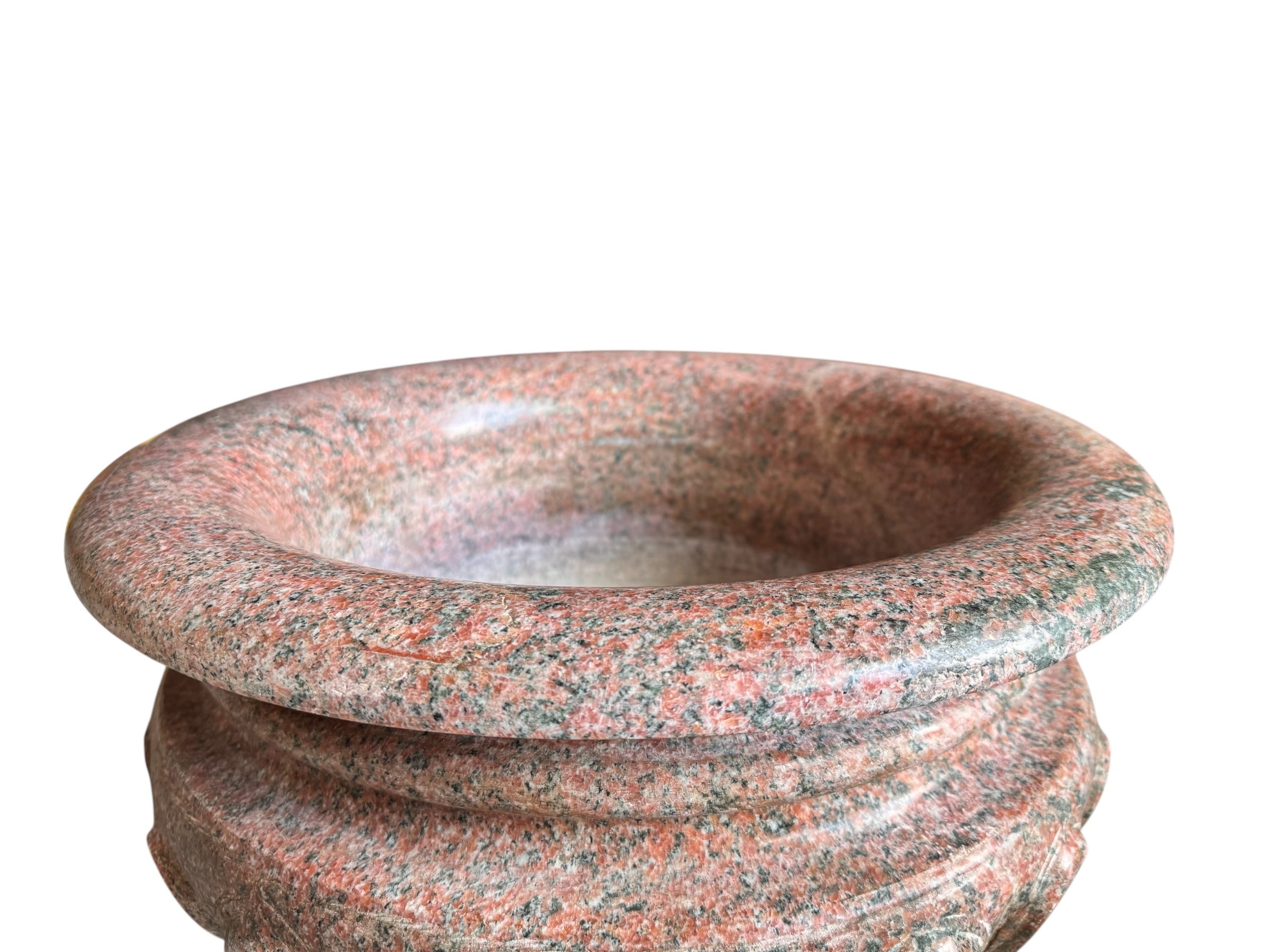 A carved pink granite planter with a leaf pattern, designed for indoor use without drainage.