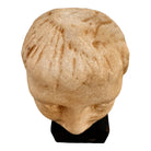 An ancient marble sculpted head of a young man, presented on a modern black presentation stand. The sculpture is rendered in a three-quarter view, angled slightly to the right, showing a classical profile characterized by a strong nose, softly contoured cheekbones, and slightly parted lips that convey a quiet, contemplative expression. The hair is carved in short, stylized strands that frame the forehead and ears, characteristic of ancient Roman or Greek portraiture styles.