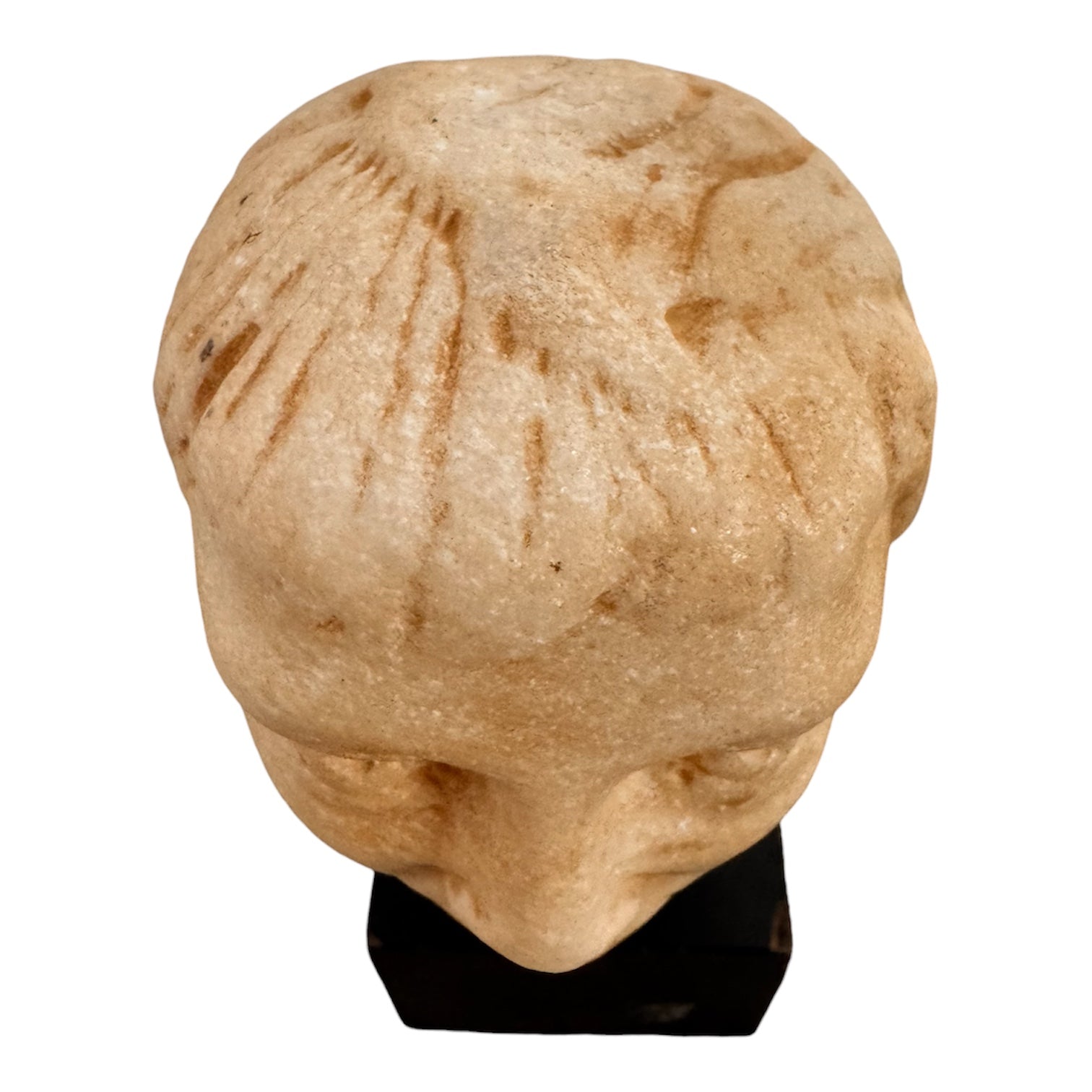 An ancient marble sculpted head of a young man, presented on a modern black presentation stand. The sculpture is rendered in a three-quarter view, angled slightly to the right, showing a classical profile characterized by a strong nose, softly contoured cheekbones, and slightly parted lips that convey a quiet, contemplative expression. The hair is carved in short, stylized strands that frame the forehead and ears, characteristic of ancient Roman or Greek portraiture styles.