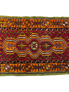 Anatolian Yastik rug with red, gold, green and gray geometric patterns and fringe.

