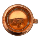 The set includes a large, rectangular, hammered copper tray with geometric openwork handles. Resting on the tray is a tall, slightly tapered copper coffee pot with a wooden handle, a matching smaller creamer pitcher with a similar wooden handle, a lidded sugar bowl, and a tiny matching metal cup or jigger. To the right off the tray sits a large, spherical copper water pitcher or jug with a wide mouth and ice lip.