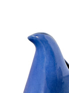A Russel Wright American Modern stoneware water pitcher in a glossy Manitoga blue glaze is centered against a white background. The pitcher has a teardrop shape, a large handle, and a wide spout