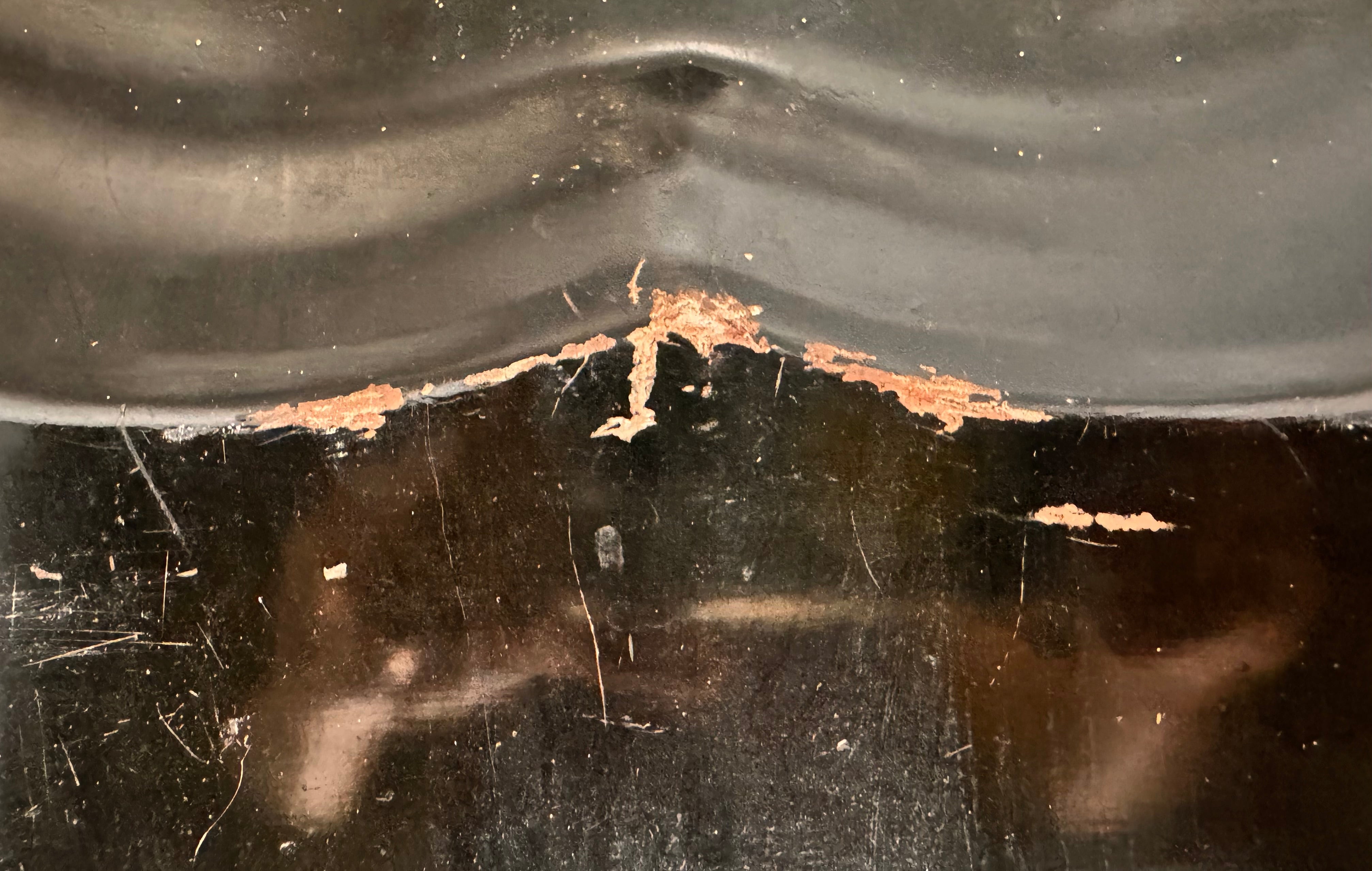 A vintage rectangular toleware serving tray with a scalloped, wavy edge and a black lacquered finish. The tray features hand-painted floral motifs in a traditional folk-art style. At the bottom center is a large, vibrant cluster of yellow and orange roses and daisies with green leaves. Smaller floral sprays and delicate gold filigree scrollwork decorate the corners and the upper rim. The center of the tray is open black space, showing light surface wear and minor scuffing consistent with age.